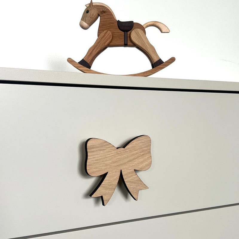 Håndtag på kommode i træ formet som en sløjfe